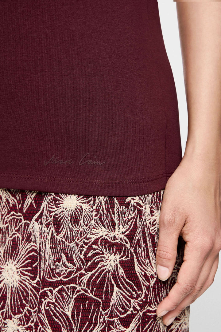 T-shirt manches courtes bordeaux avec jupe à motifs floraux, vue détaillée de la texture et de la bordure.