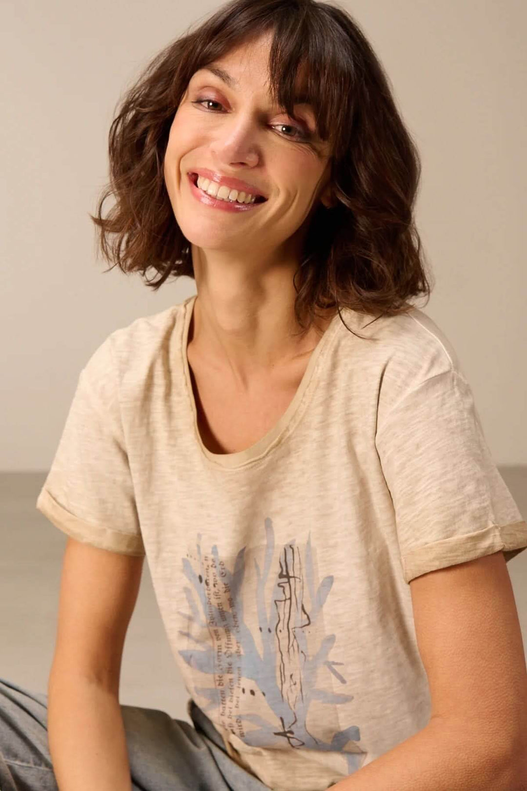 Femme souriante portant un T-shirt à manches courtes coupe décontractée avec motif imprimé.