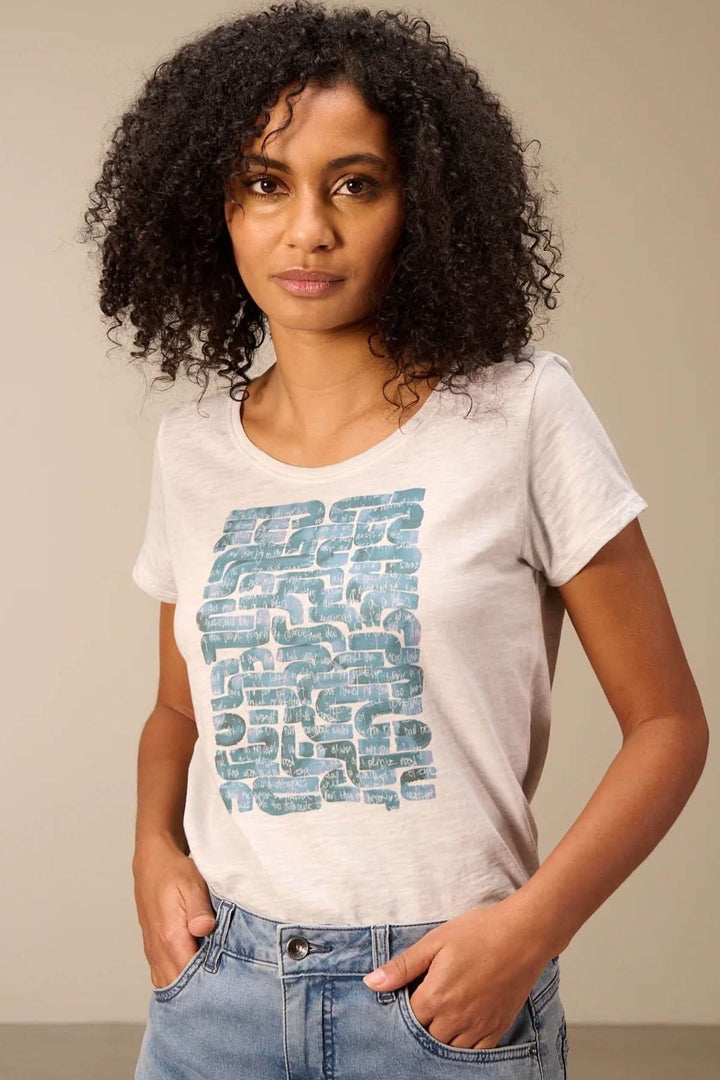 Femme portant un T-shirt à manches courtes coupe décontractée avec motif graphique bleu, parfait pour le quotidien.