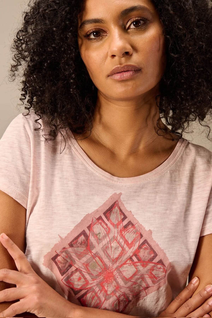 Femme portant un T-shirt à manches courtes coupe décontractée avec un motif graphique, tissu doux et léger.