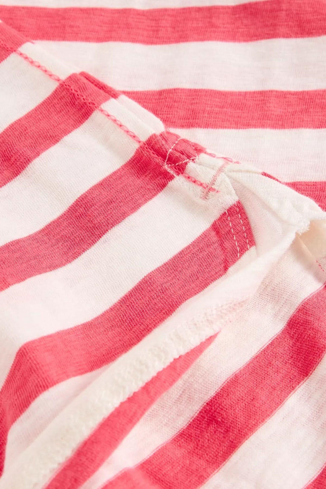 Détail du tissu rayé rouge et blanc du T-shirt rayé à manches longues avec finition bord-côte élégante.