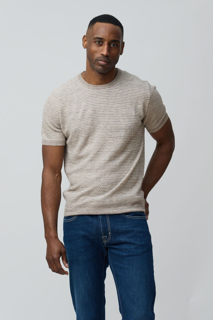 Homme portant un T-shirt texturé en lin et soie, coupe ajustée, maille sophistiquée. Décris moi le produit en français.