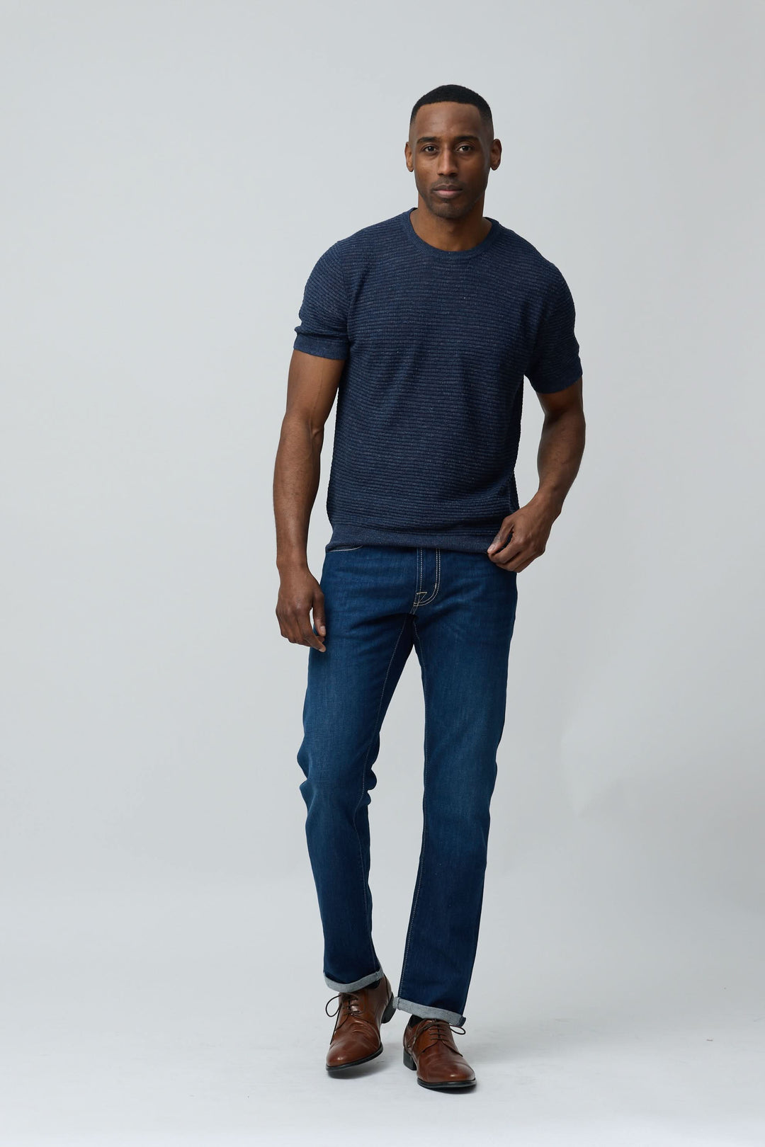 Homme portant un T-shirt texturé en lin et soie avec jean et chaussures, allure moderne et épurée