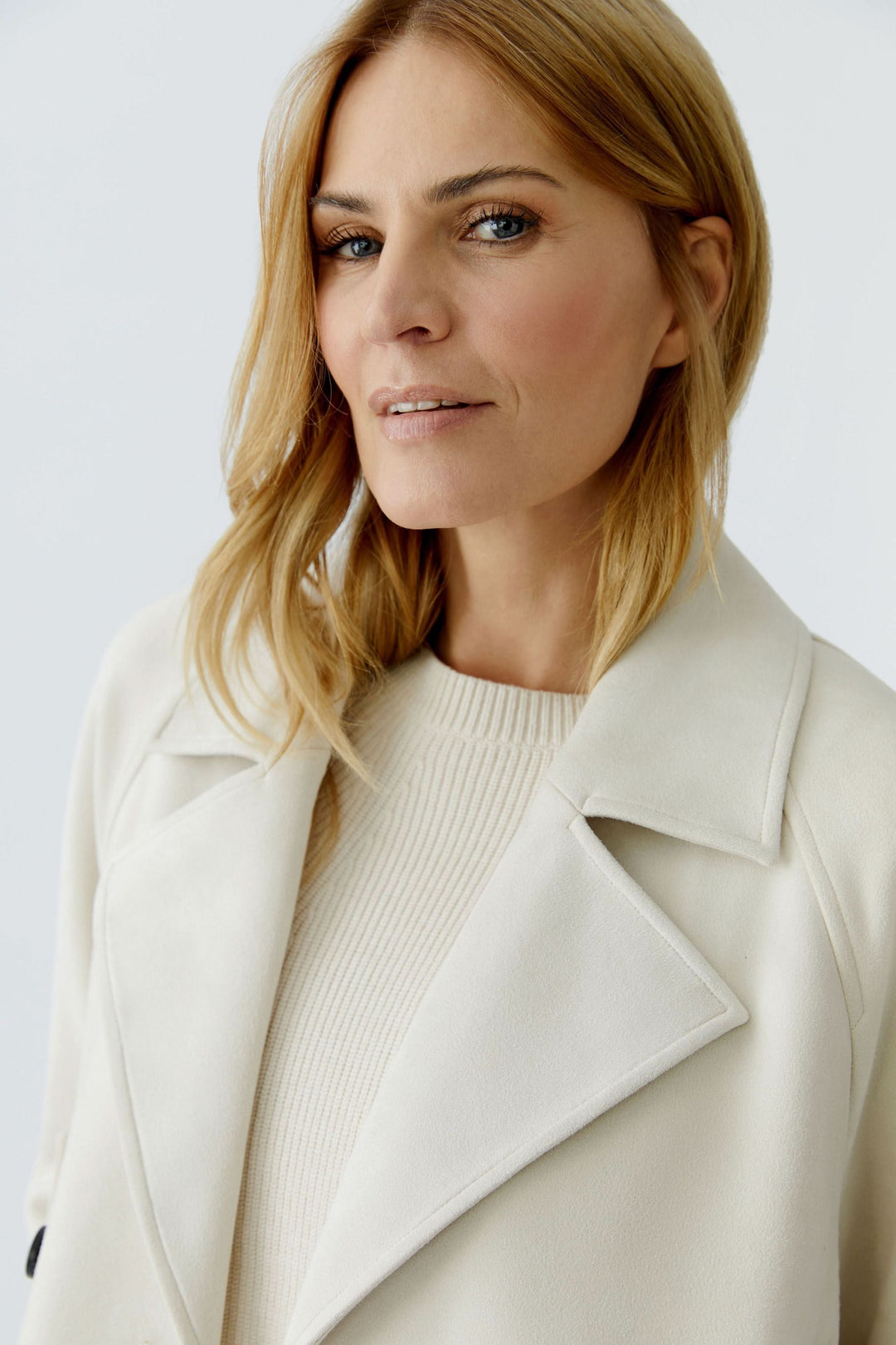 Femme portant une veste courte croisée à col tailleur, style moderne et raffiné, idéal pour looks décontractés ou habillés.