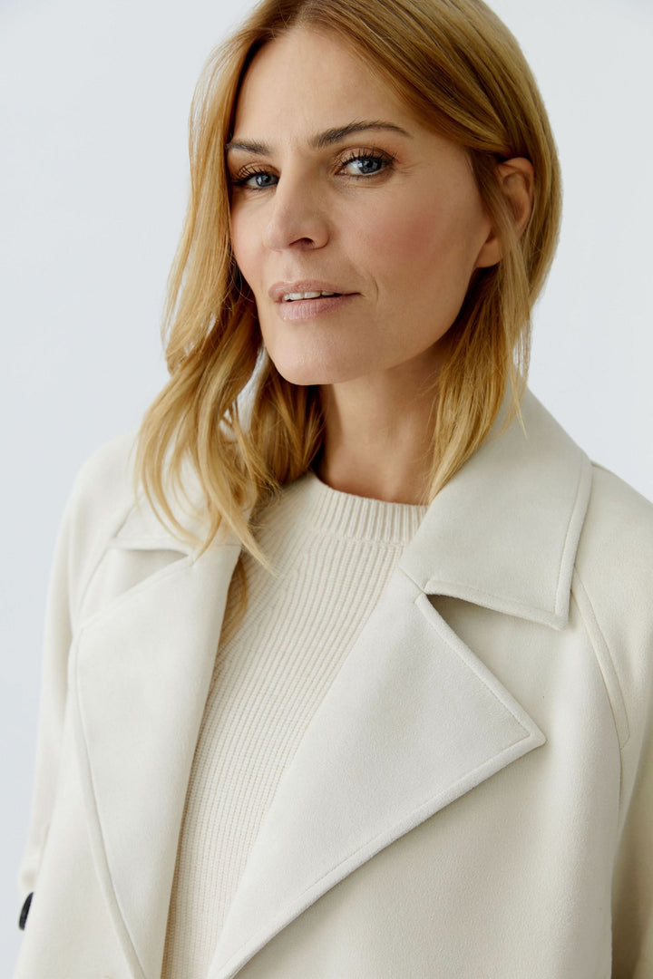 Femme portant une veste courte croisée à col tailleur, style moderne et raffiné, idéal pour looks décontractés ou habillés.