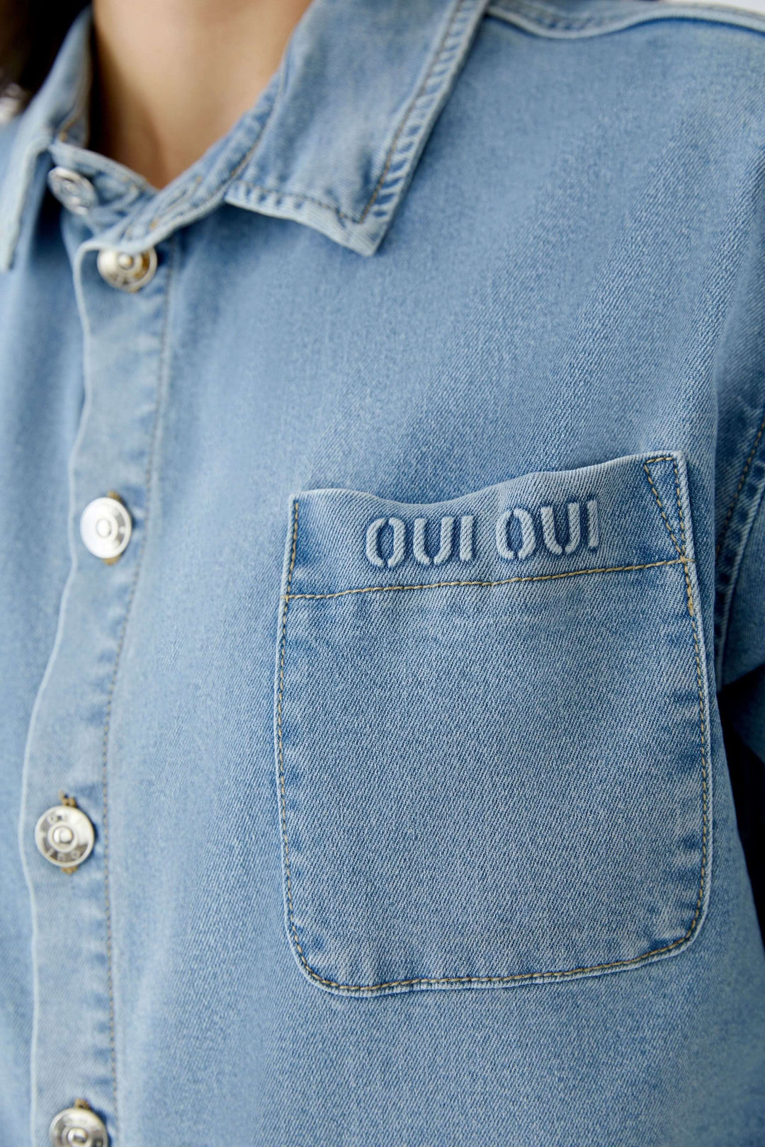 Veste en denim avec style moderne et coupe droite, boutonnière et poche brodée "Oui Oui" pour une tenue quotidienne chic.