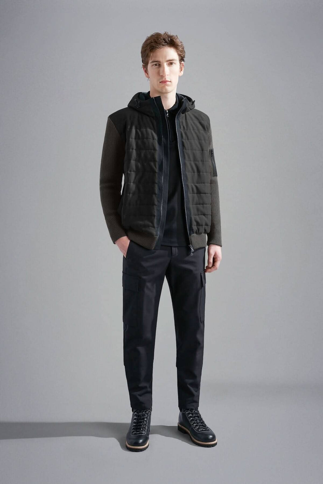 Homme portant une veste imperméable à capuchon Paul &amp; Shark, idéale pour le froid, avec matelassage léger.