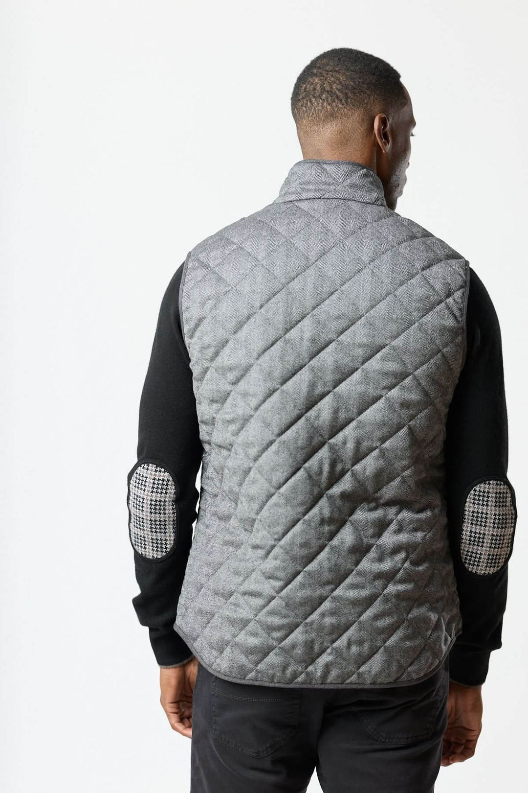 Veste sans manches matelassée en laine à motif chevrons vue de dos, élégance italienne et texture herringbone raffinée.