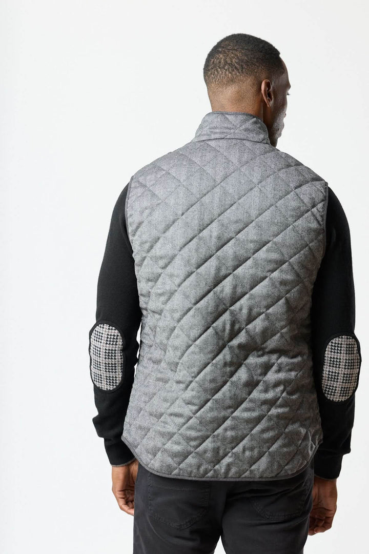 Veste sans manches matelassée en laine à motif chevrons vue de dos, élégance italienne et texture herringbone raffinée.