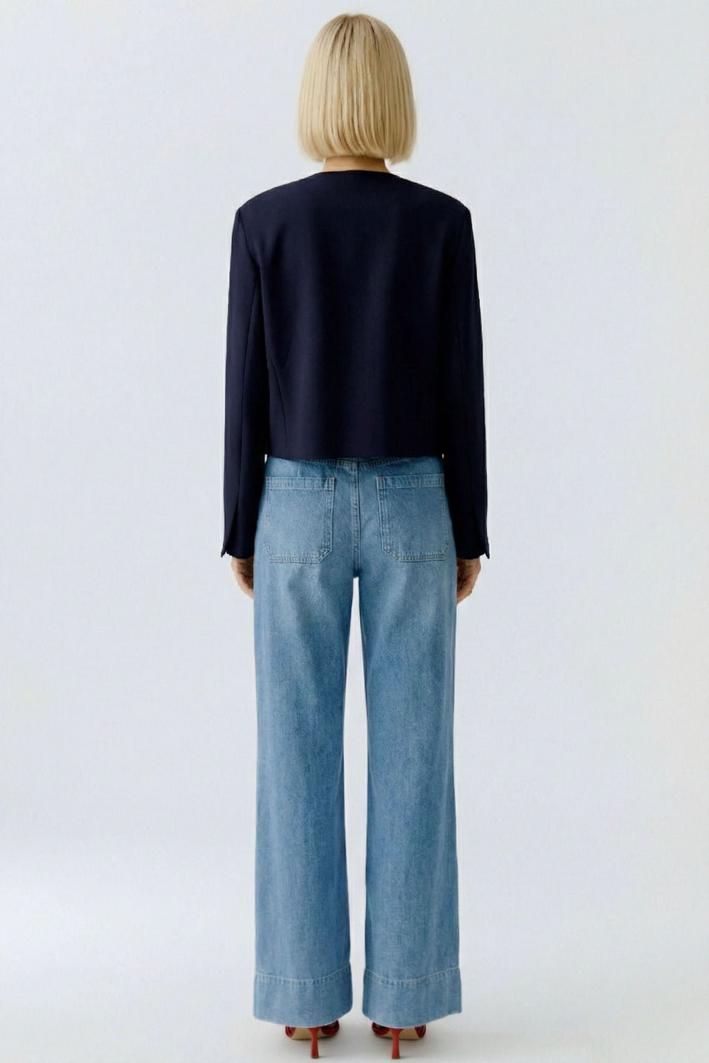Veste structurée à boutons décoratifs vue de dos, portée avec un jean.