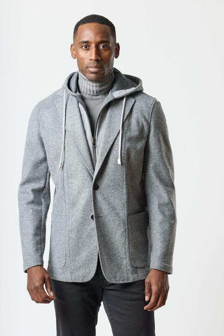 Veston hybride à capuche en laine grise avec capuche intégrée, porté sur un col roulé gris pour un look élégant et urbain.