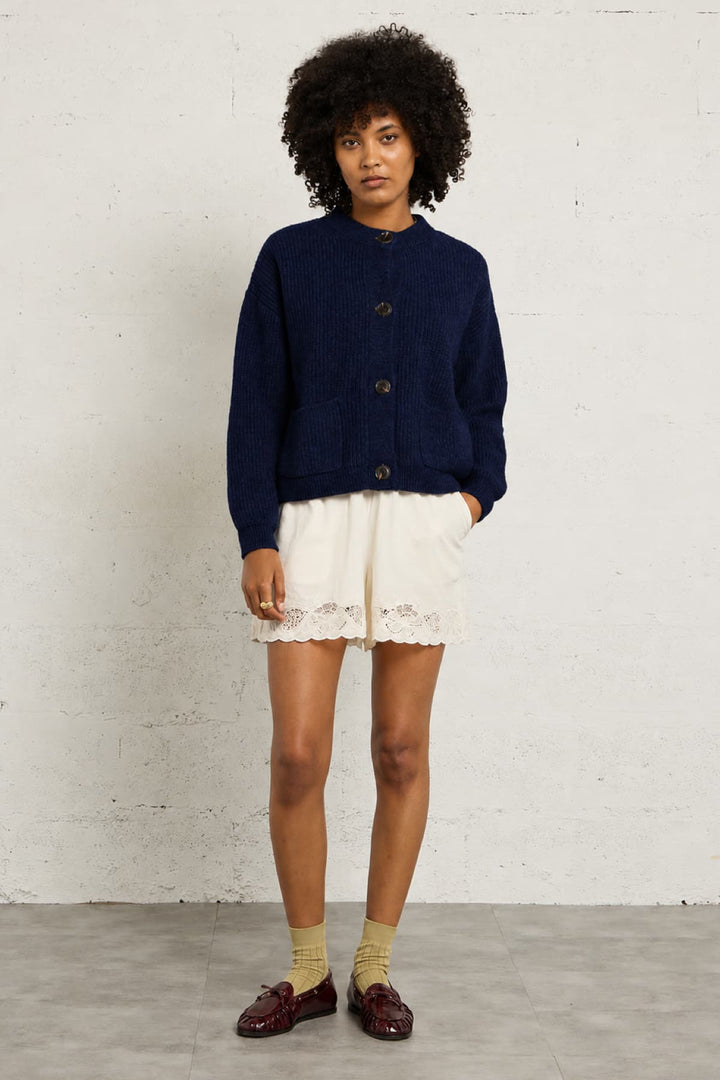 Front view of the beige ribbed JC SOPHIE cardigan with pockets worn by Valérie Simon