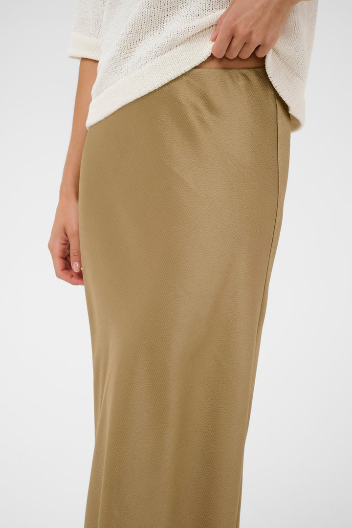 Side view of a long, textured blue Kaffe skirt worn by Valérie Simon