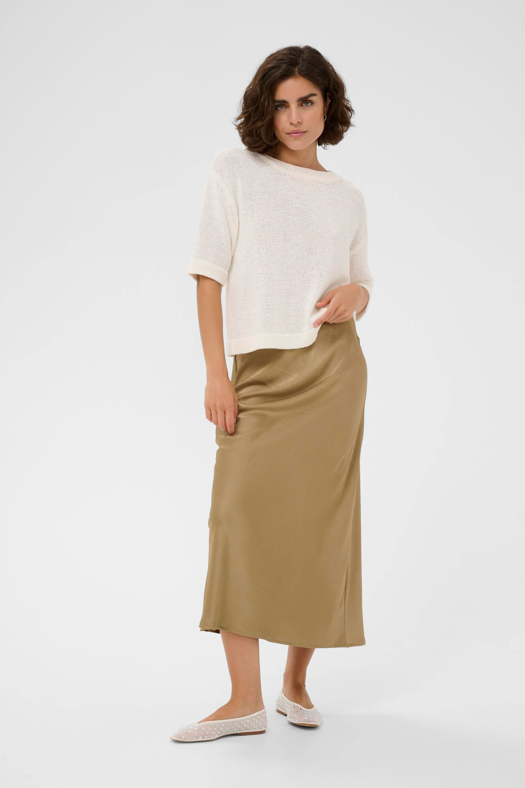 Side view of a long, flowing, textured beige Kaffe skirt with pleated details - Valérie Simon