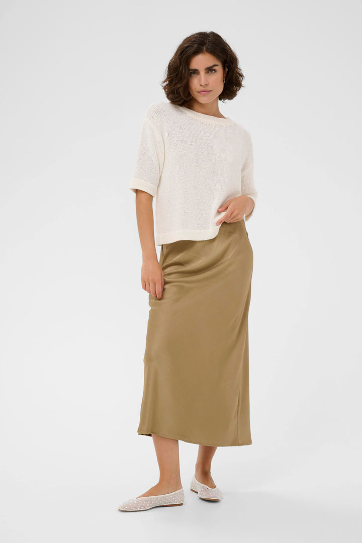 Side view of a long, flowing, textured beige Kaffe skirt with pleated details - Valérie Simon