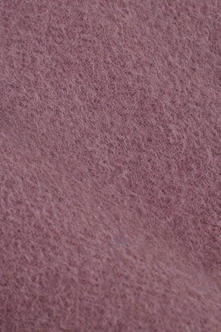 Zoom sur le tissu doux en laine du foulard Anna, couleur rose chaud et texturé.