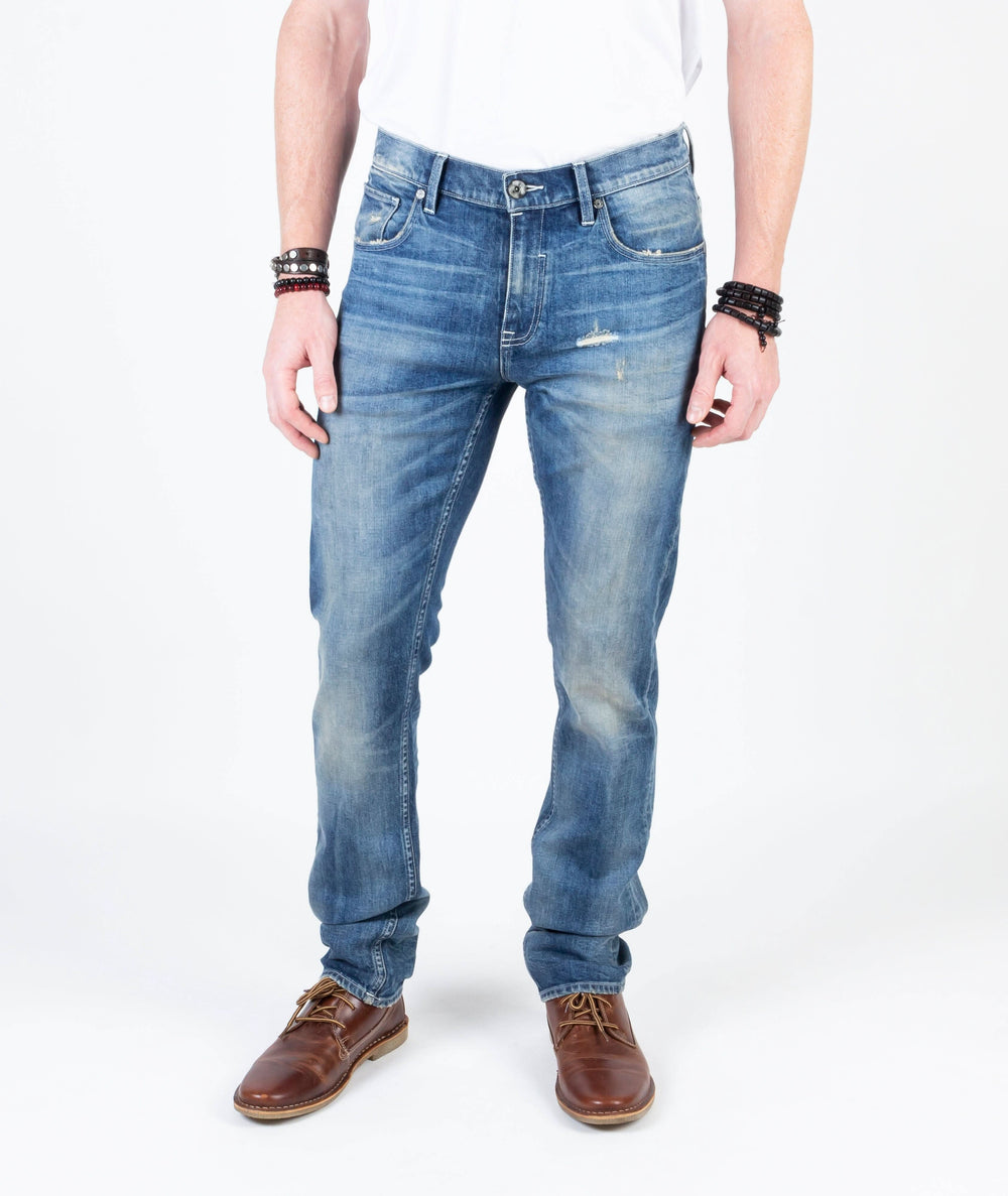 Jean Axe Lazuli en denim italien, conçu en coton bio, style vintage, taille ajustée, porté par un homme.