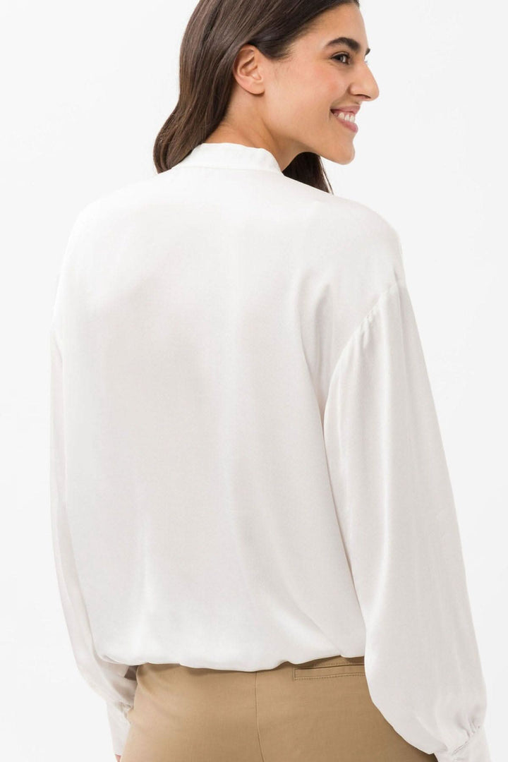 Vue arrière de la blouse soyeuse Viv, à manches bouffantes et col montant, coloris blanc, en viscose confortable.