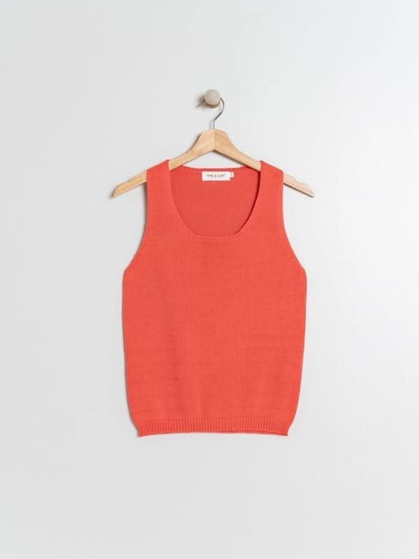 Camisole en tricot fin orange avec encolure en U, idéale pour l'été, hangée sur un portant.