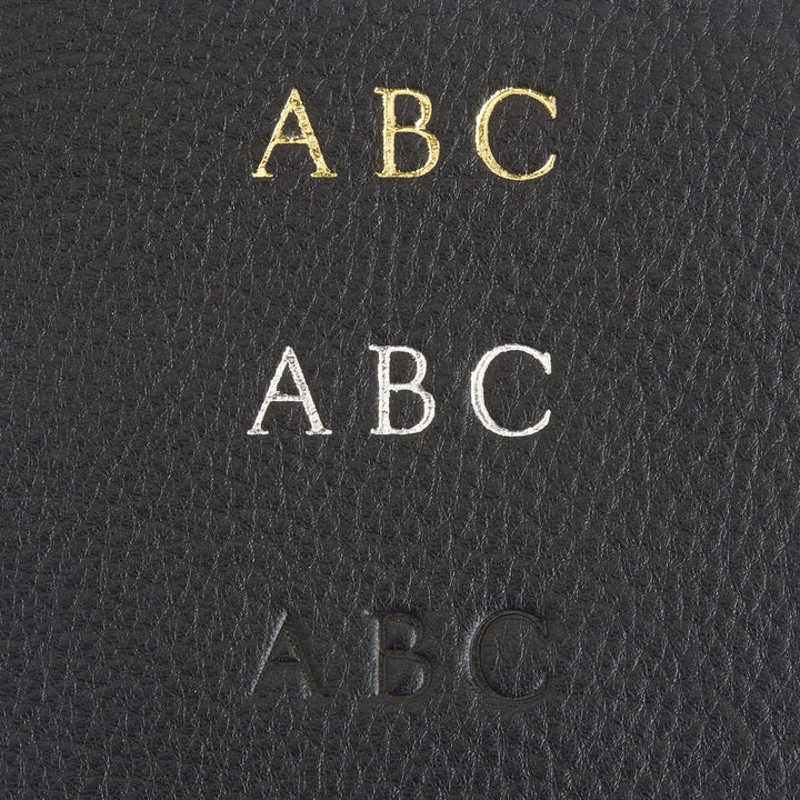 Monogram personalization options in gold, silver, and blind embossing on black leather for a custom wallet.