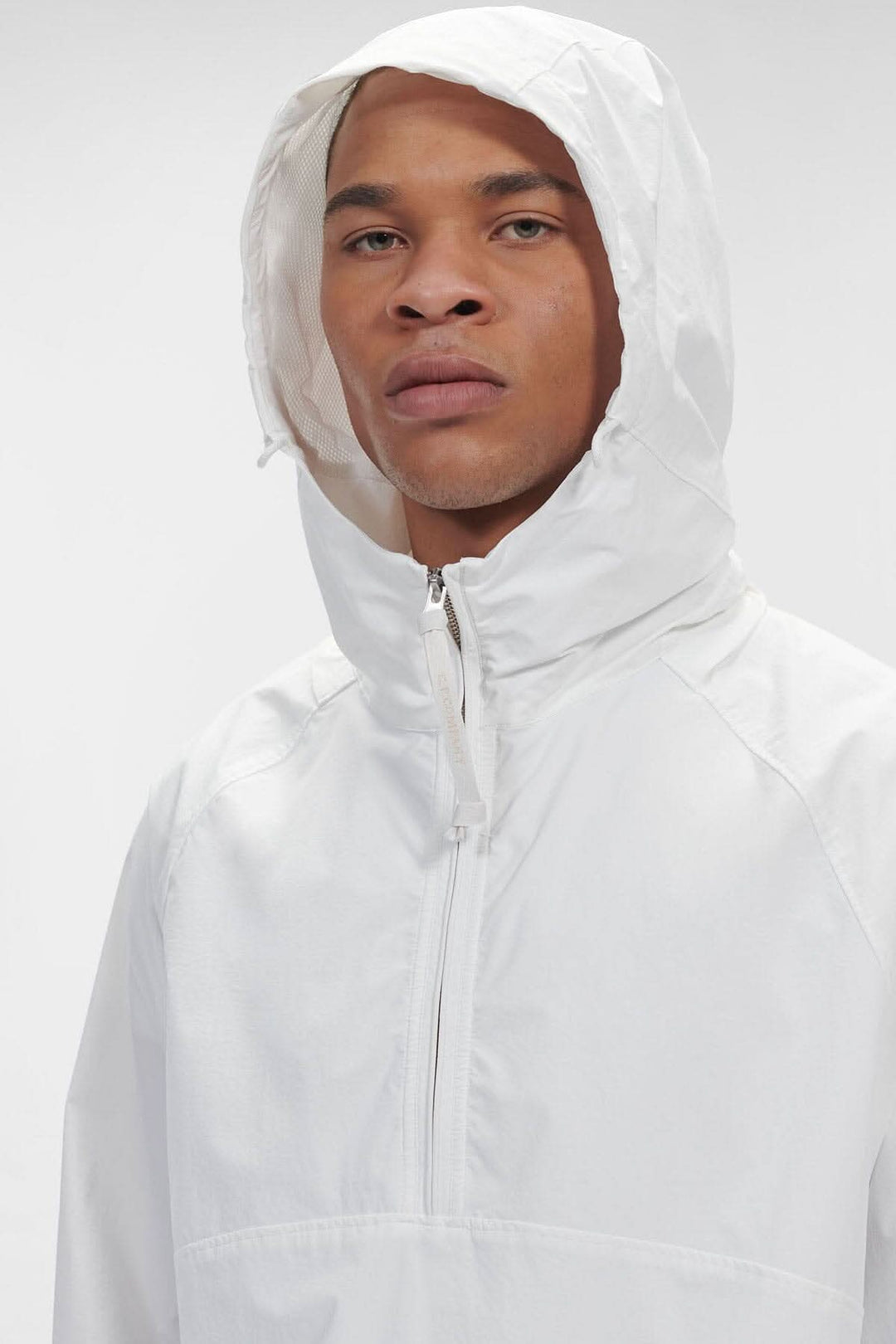 Homme portant un sweat-shirt à capuche blanc avec demi-fermeture zippée et tissu mat résistant à l&