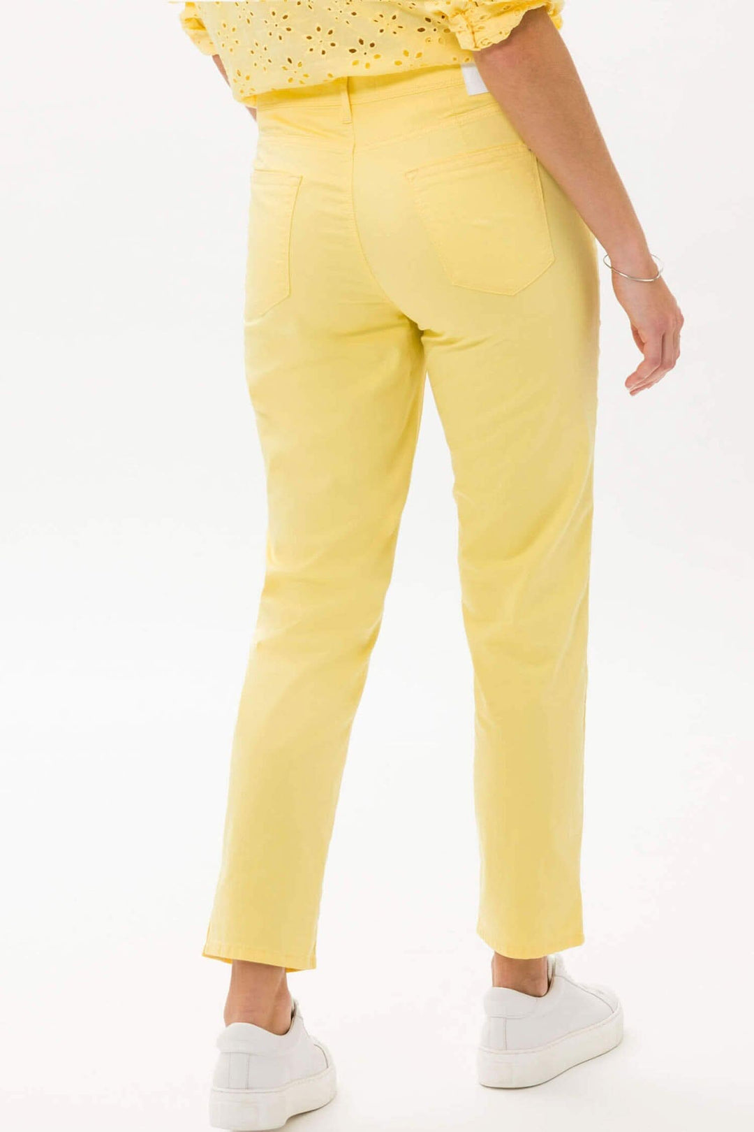 Pantalon slim jaune pour femme, coupe droite, avec poches et style décontracté.