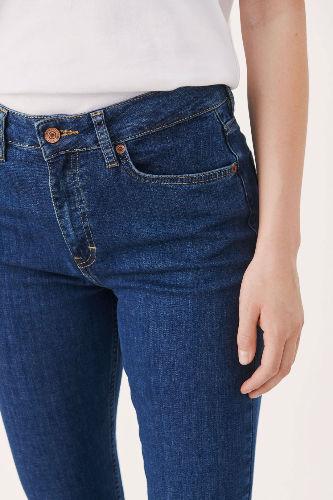 Jean ajusté à taille haute avec cinq poches, longueur au-dessus de la cheville et style bootleg.