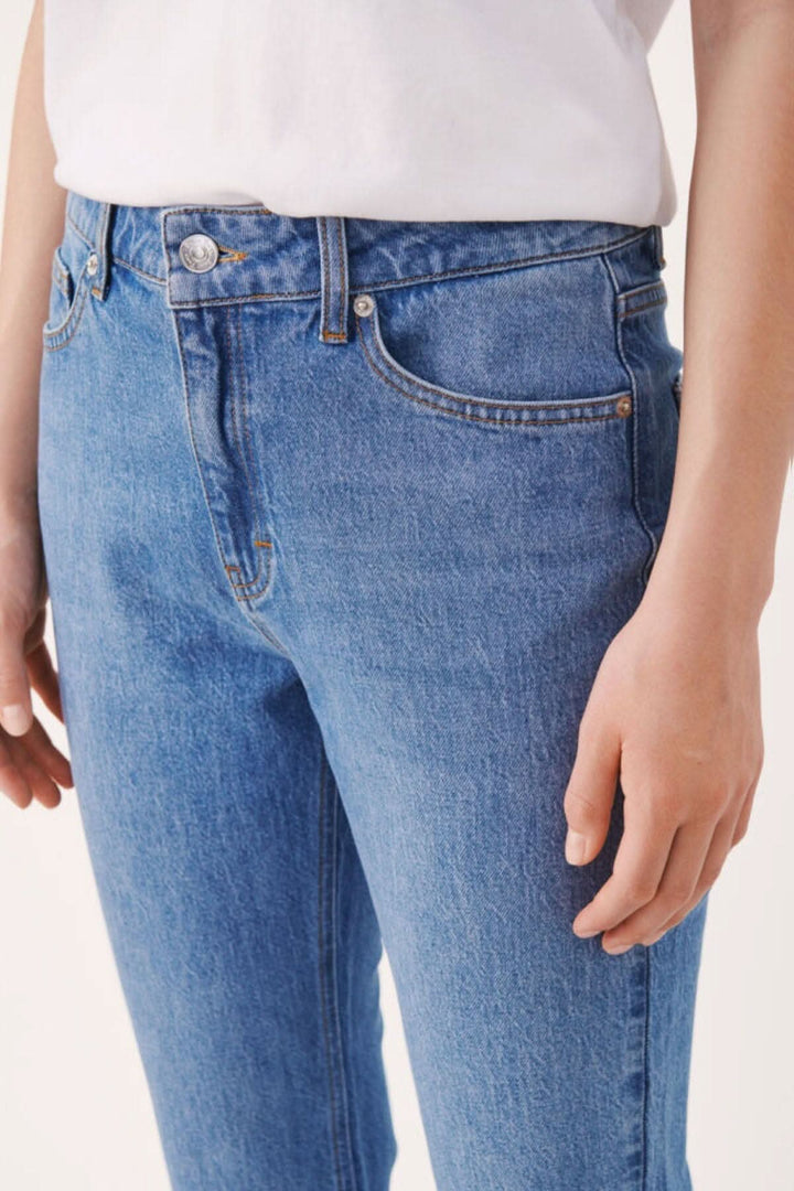 Jean Ryan en denim structuré, coupe droite, taille haute, passants de ceinture, confort et style décontracté.