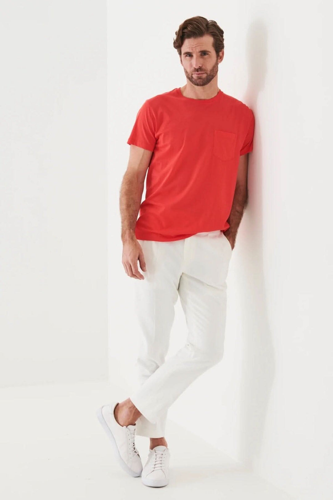 Homme portant un t-shirt léger en coton pima rouge avec une poche, style décontracté et confortable.