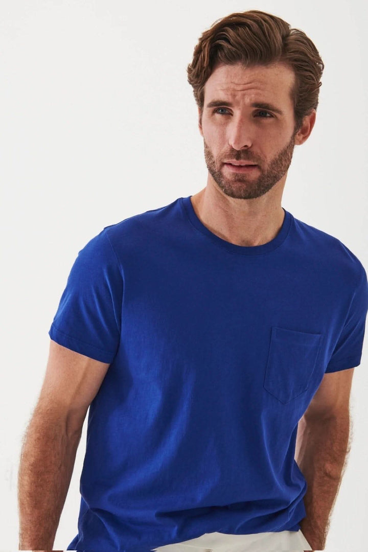 Homme portant un t-shirt léger en coton pima bleu avec poche, idéal pour temps chaud.