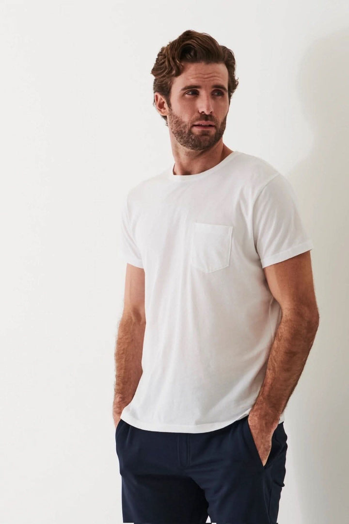 Homme portant un t-shirt léger en coton pima blanc avec une poche, idéal pour temps chaud.