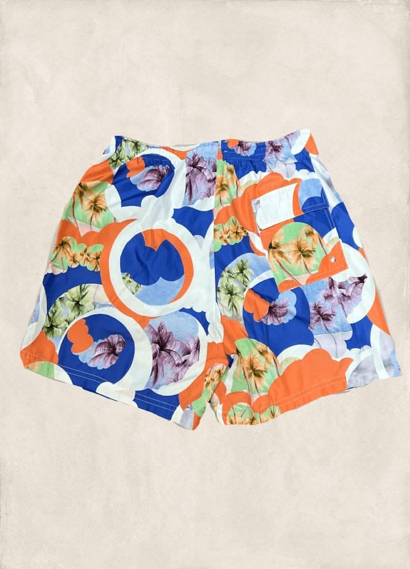 Maillot de bain coloré avec motifs floraux et géométriques en bleu, orange et blanc, parfait pour l&
