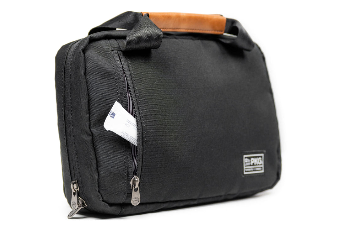 PKG Simcoe recycled essentials bag with vegan leather accents, weather-resistant fabric, and a metal hanging hook.