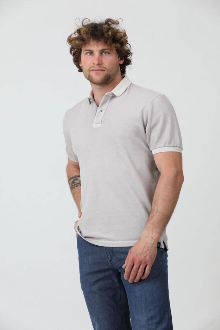 Homme portant un polo à manches courtes en jersey de coton piqué, look décontracté avec jeans.