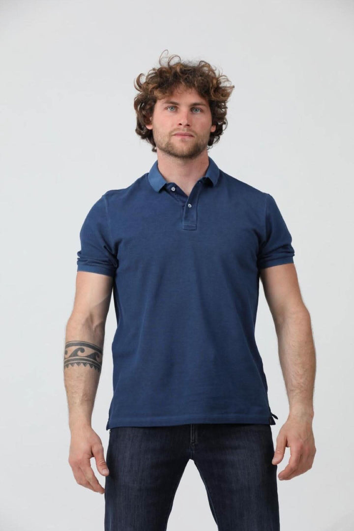 Homme portant un polo à manches courtes en jersey de coton piqué, couleur bleu marine, avec col côtelé.