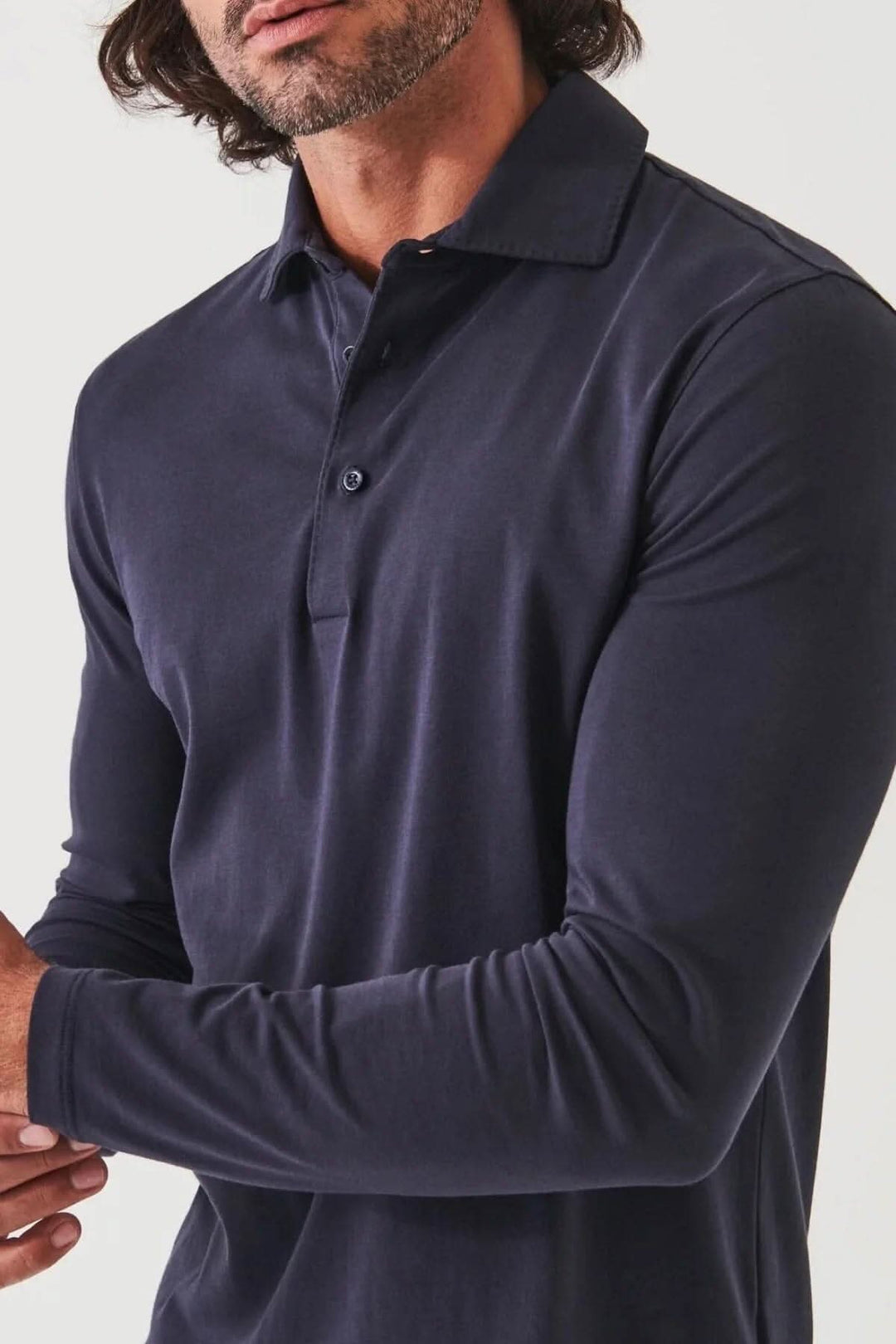 Homme portant un polo en coton stretch à manches longues de couleur bleu marine, élégant et décontracté.