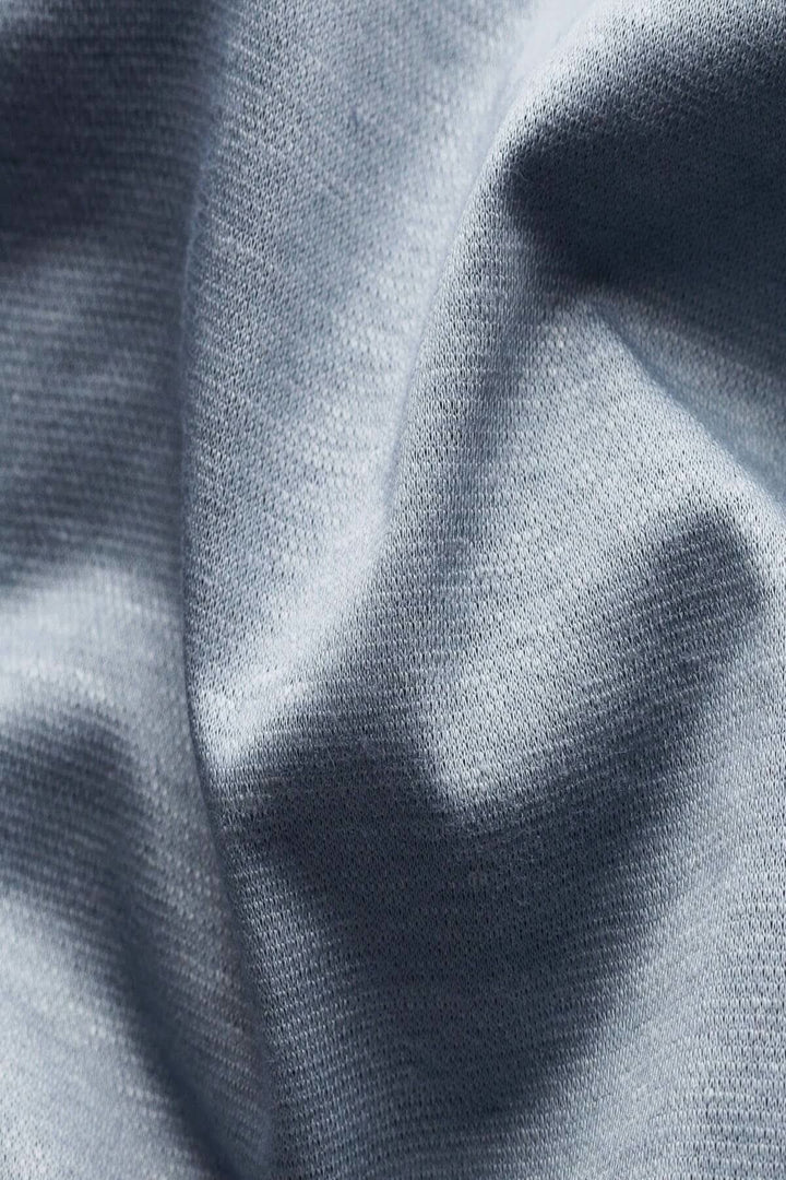 Tissu en coton et lin de couleur bleue, montrant une texture douce et respirante, idéal pour un polo.