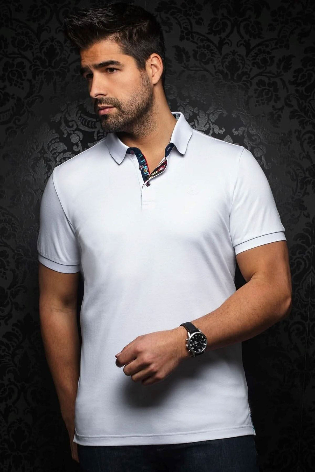 Homme portant un polo blanc élégant avec col contrastant, mettant en avant style et confort.