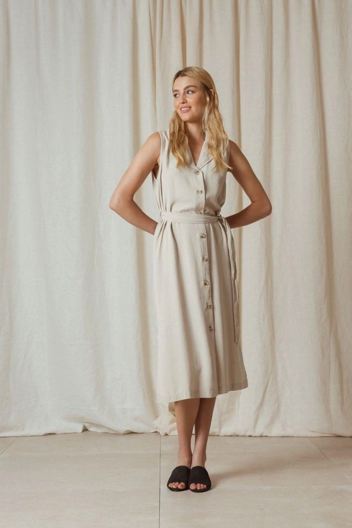 Robe en piqué de lyocell avec ceinture, col à revers et boutonnière centrale, couleur beige.