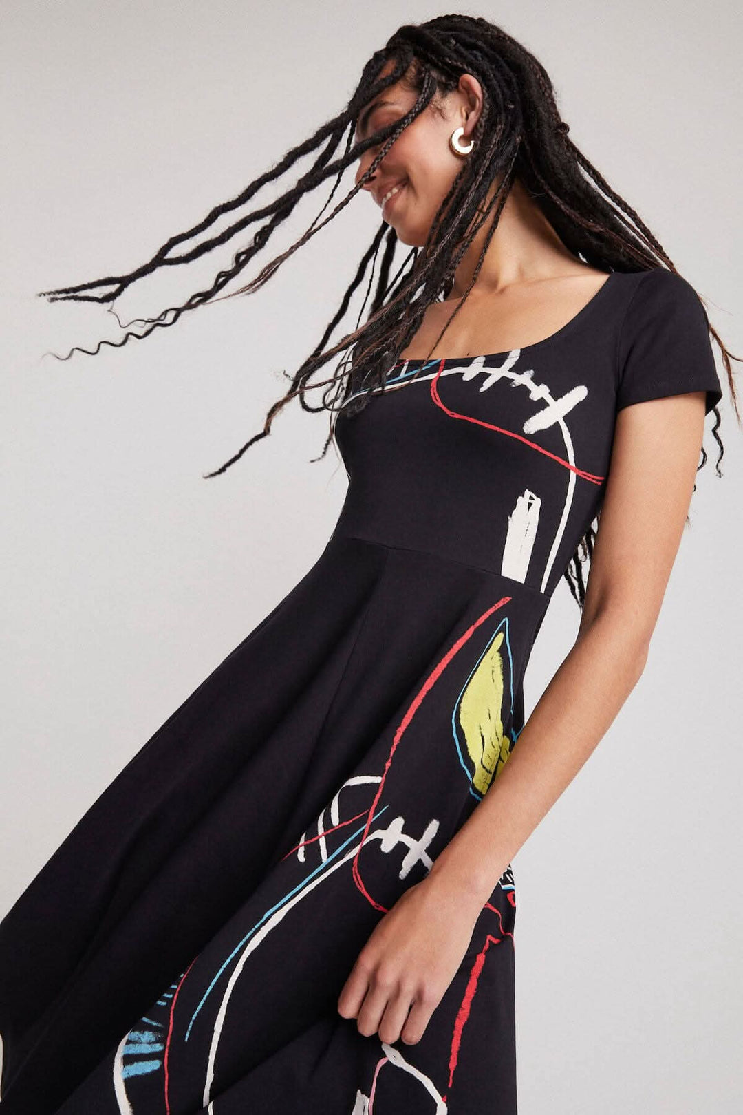 Robe longue noire à imprimé artistique, coupe trapèze, manches courtes et encolure carrée.