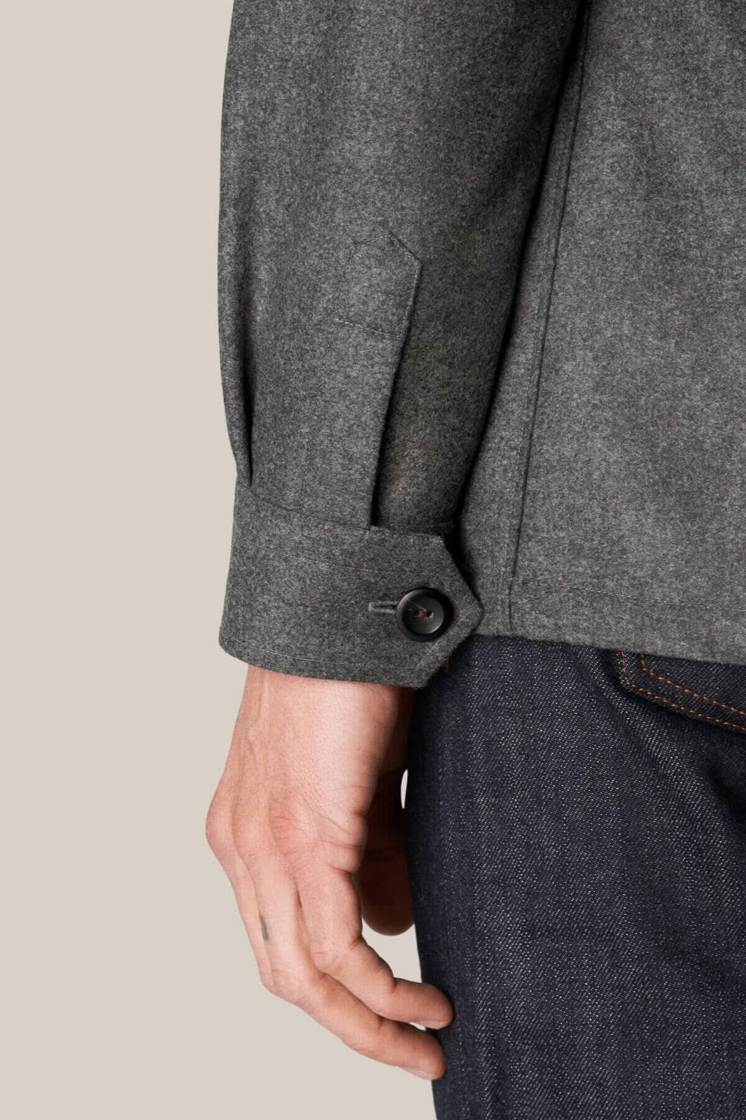 Détail de la surchemise en laine cachemire avec un poignet boutonné, tissu épais gris, style extérieur.