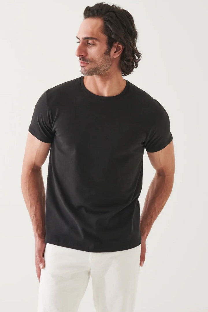 Homme portant un t-shirt basique noir, coupe moderne, avec une encolure ronde et manches courtes.