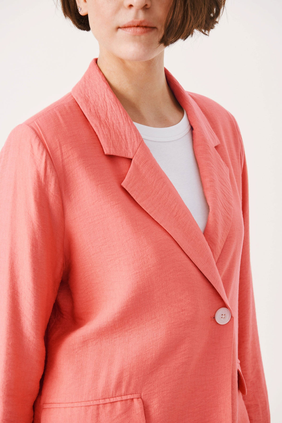 Veston Talena femme en couleur corail avec col classique et bouton, style décontracté.